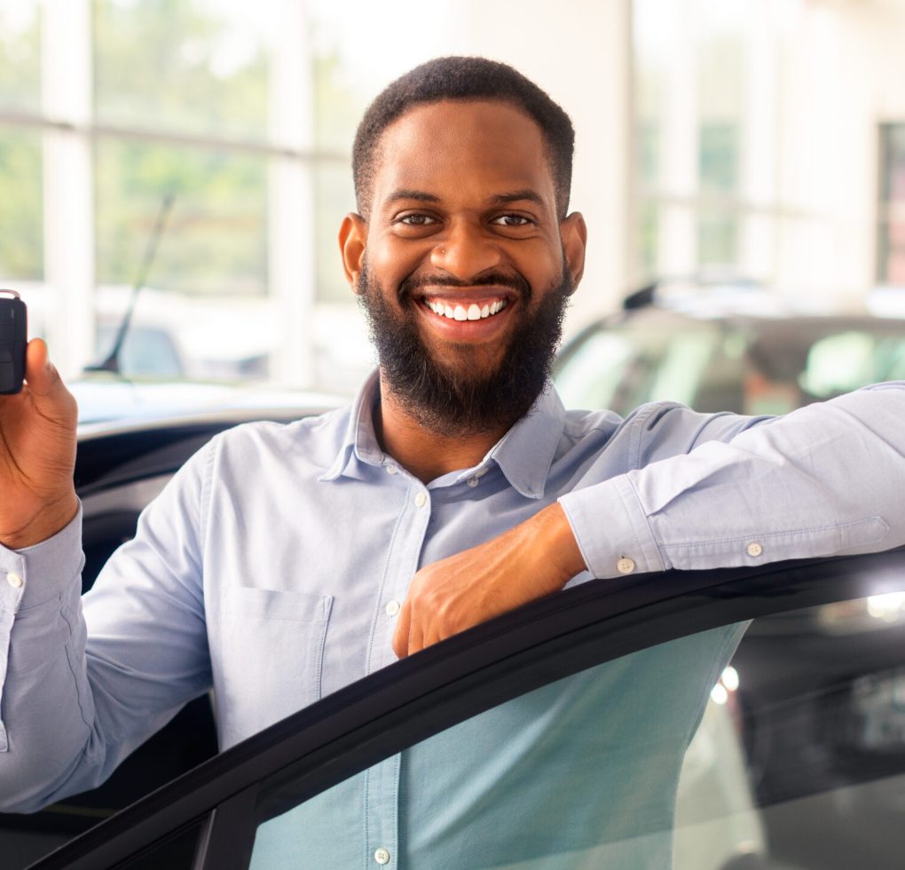 Car Credit Concept. Happy Black Male With Car Keys In hand Posing Near New Automobile, Cheerful African American Man Leaning On Automobile Door And Smiling At Camera, Closeup Shot With Free Space